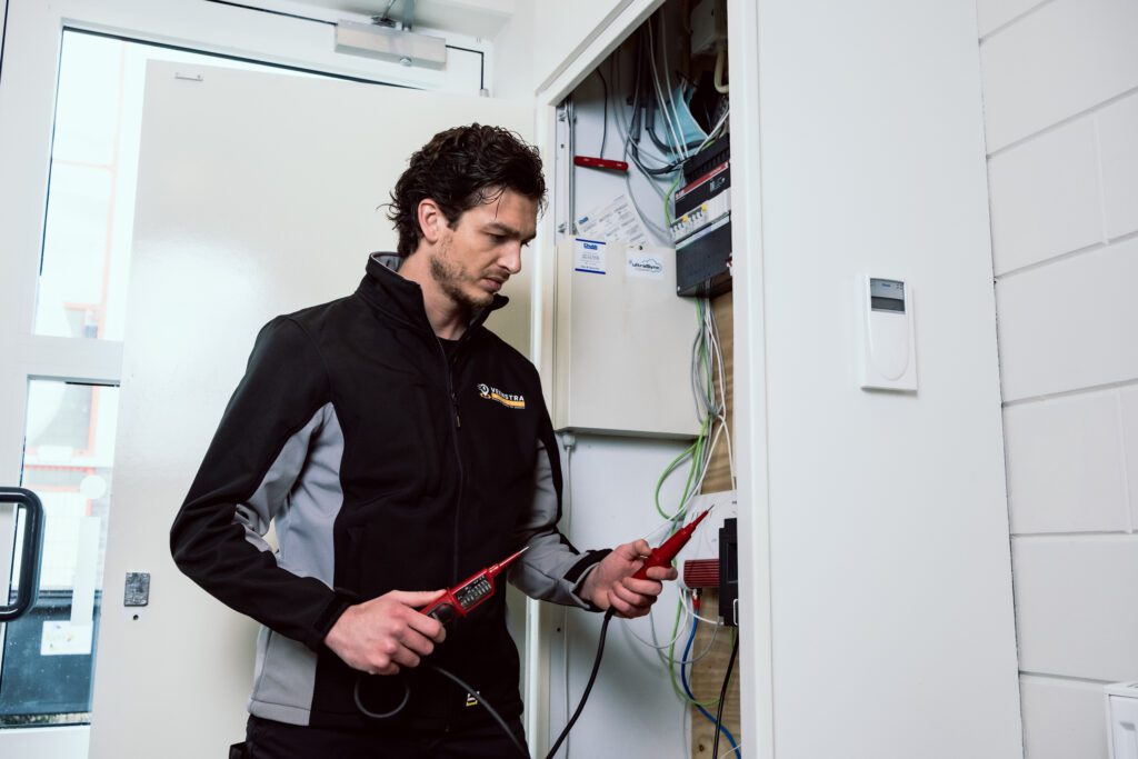 elektricien bij de meterkast die verschillende testen doet in de meterkast